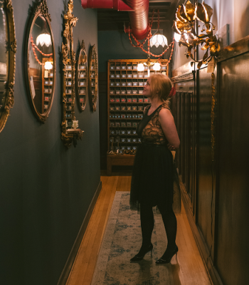 woman in narrow hallway looking at mirrors