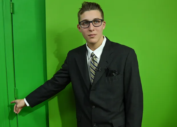 Tanner Cero, 15, standing before a green screen.