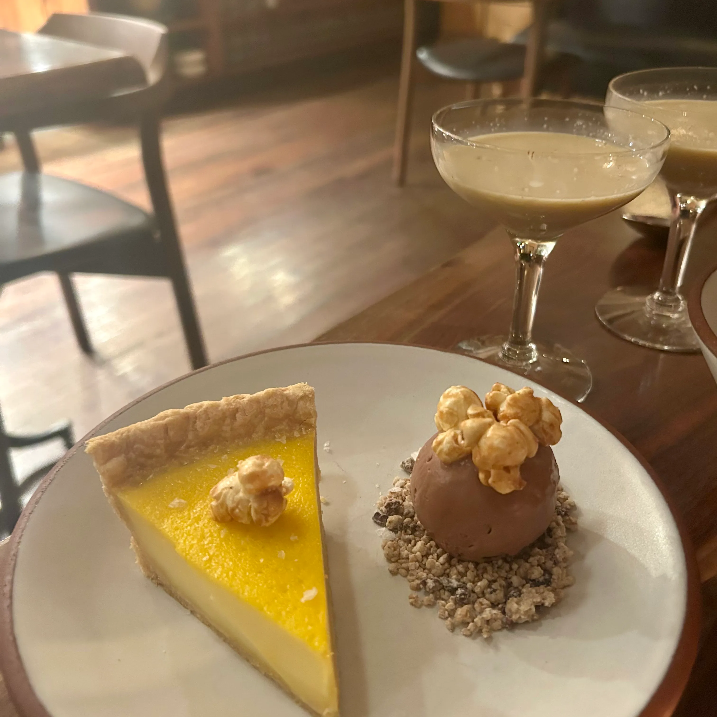 The popcorn pie with ice cream and benne crumble, topped with caramel corn, alongside glasses of Dabnog.