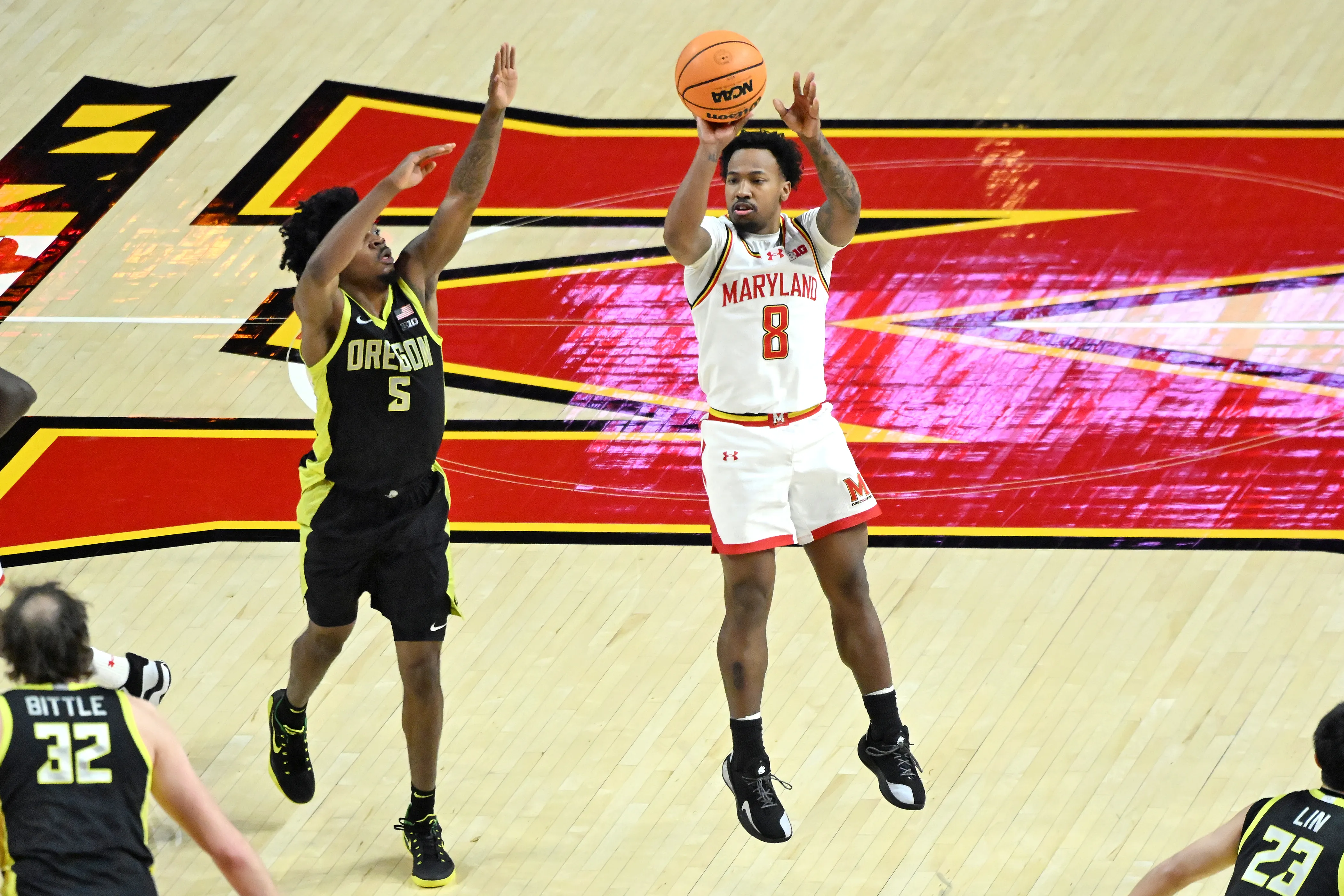 Oregon’s Takai Simpkins defends Maryland’s David Coit as he scores...
