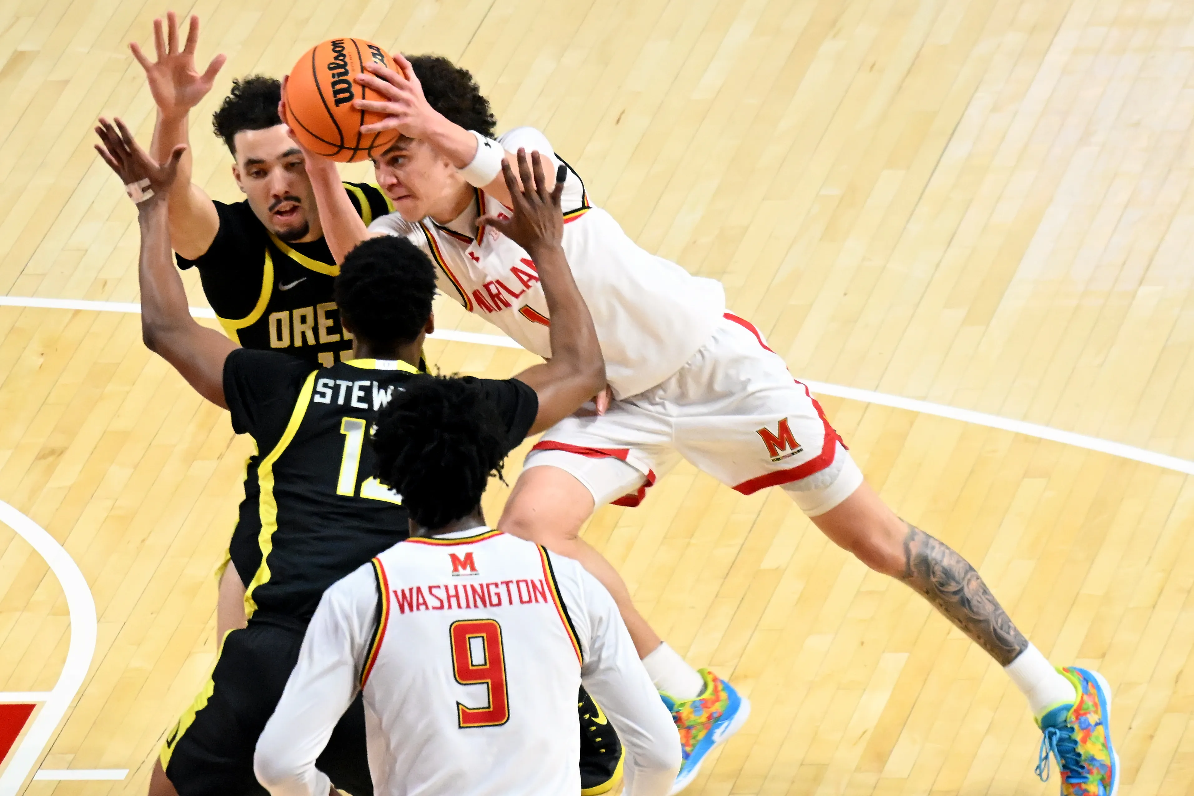 Oregon’s Drew Carter and Sean Stewart deny Maryland’s Darius Adams...
