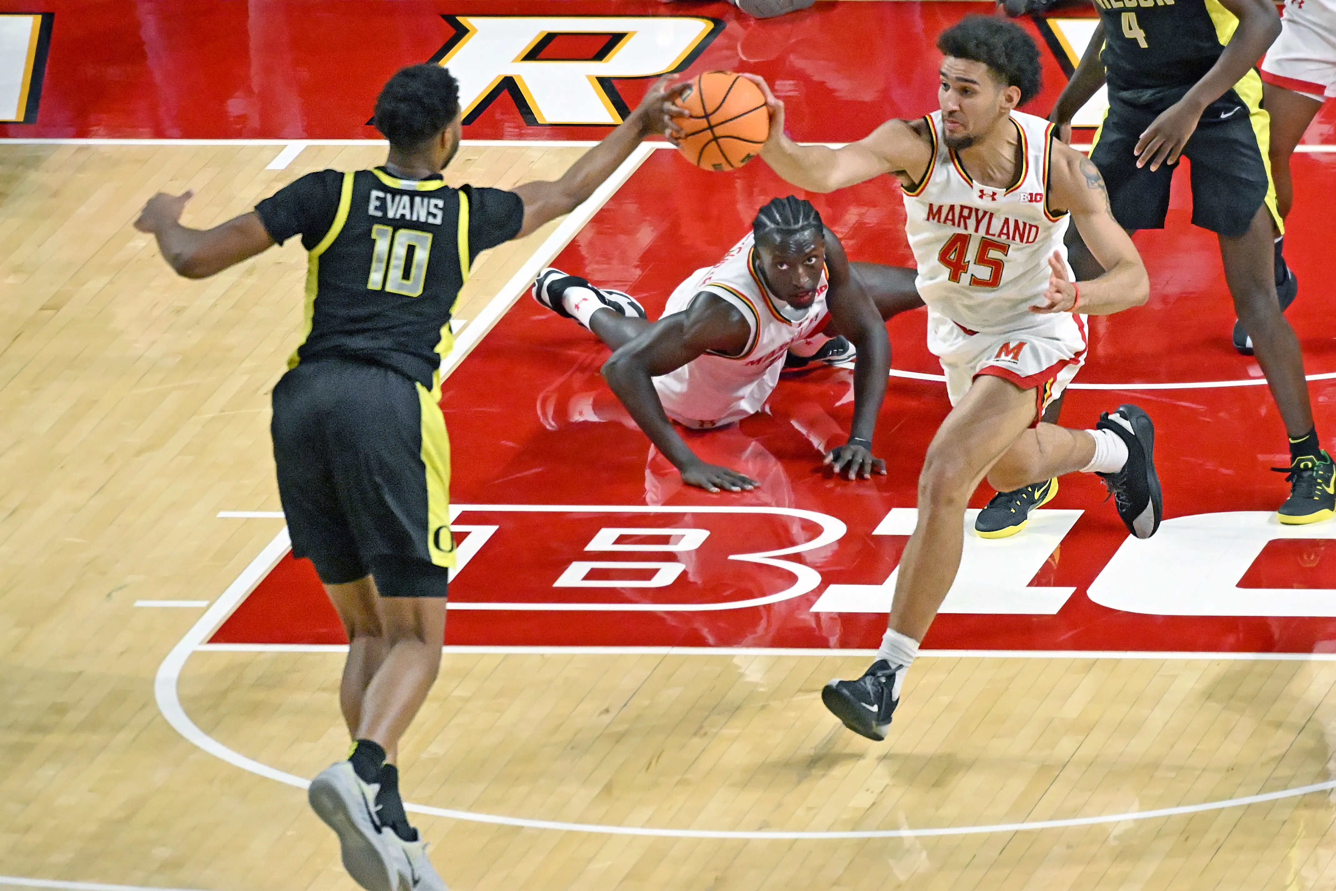 Oregon’s Kwame Evans Jr. and Maryland’s Collin Metcalf both get...