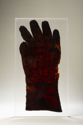 Red rubber glove in a plastic cast against a white background