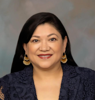 headshot of woman with long dark hair, hanging earrings, dark blazer