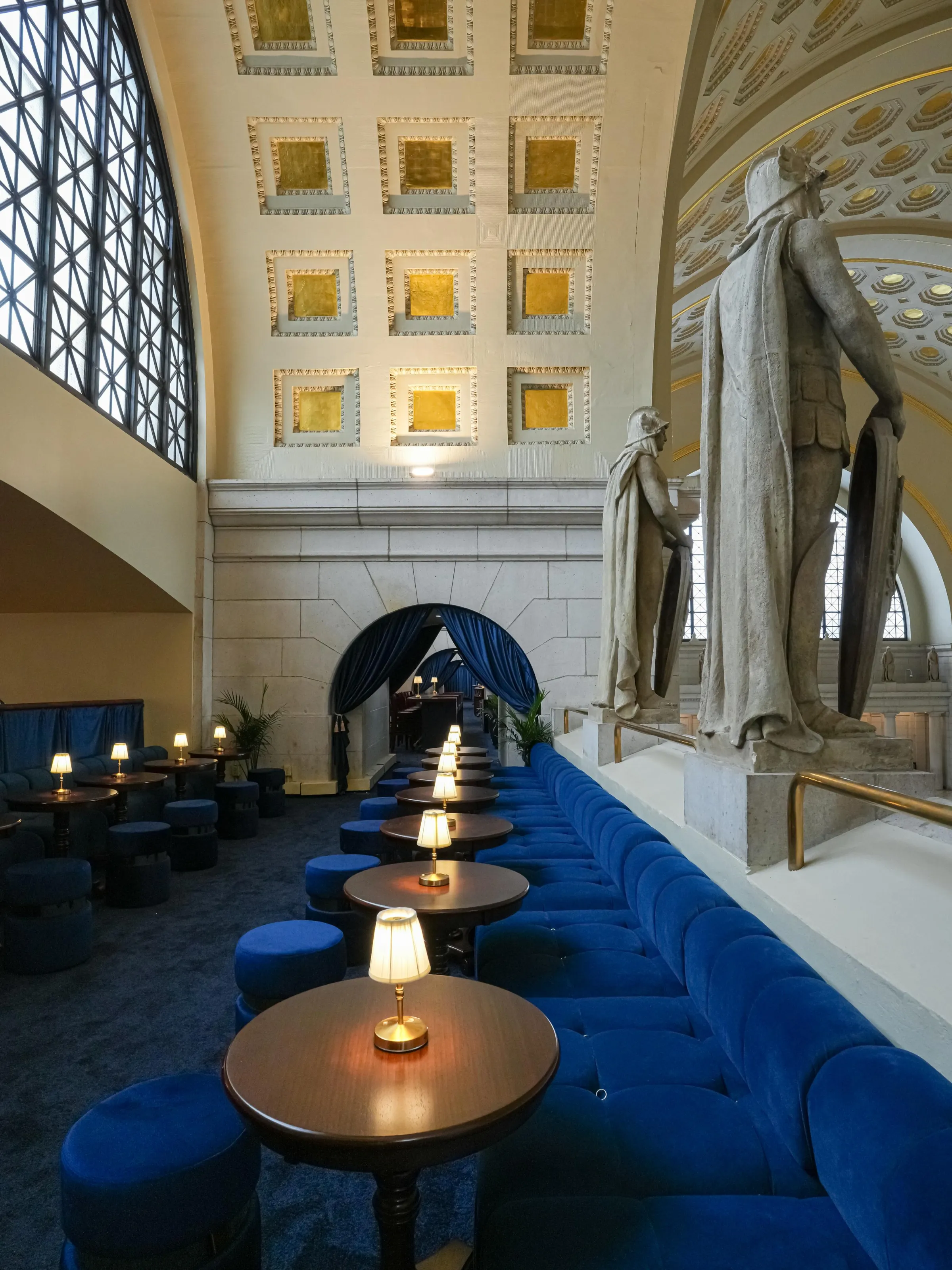 The tunnels between the open rooms are outfitted in matching blue velvet drapery.